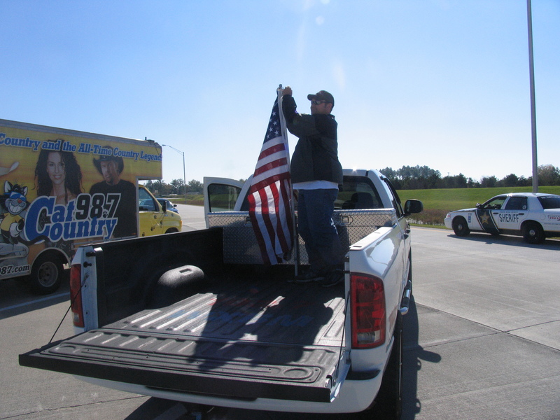 Fixing a flag to the back of a pickup truck.