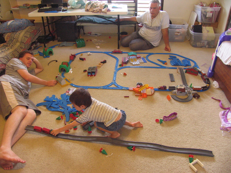 Joseph, Mikey, and Don surround the first layout.  Mikey seems more interested in the road set.